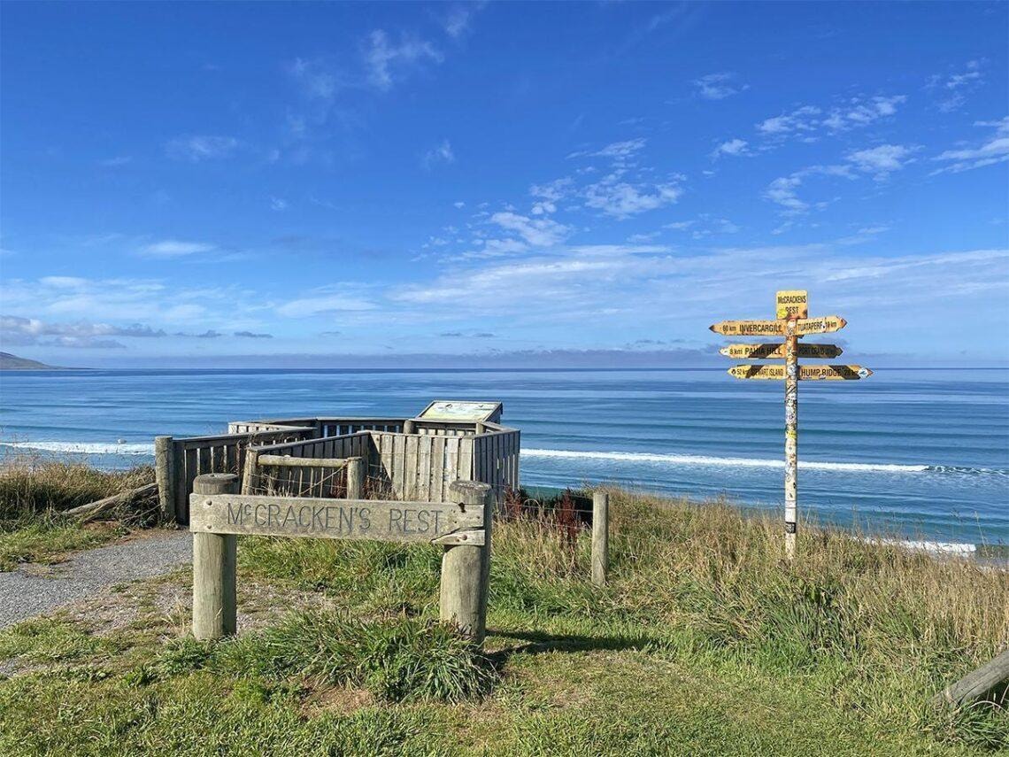 Wooden viewing platform and directional sign at McCracken's Rest overlooking the ocean.