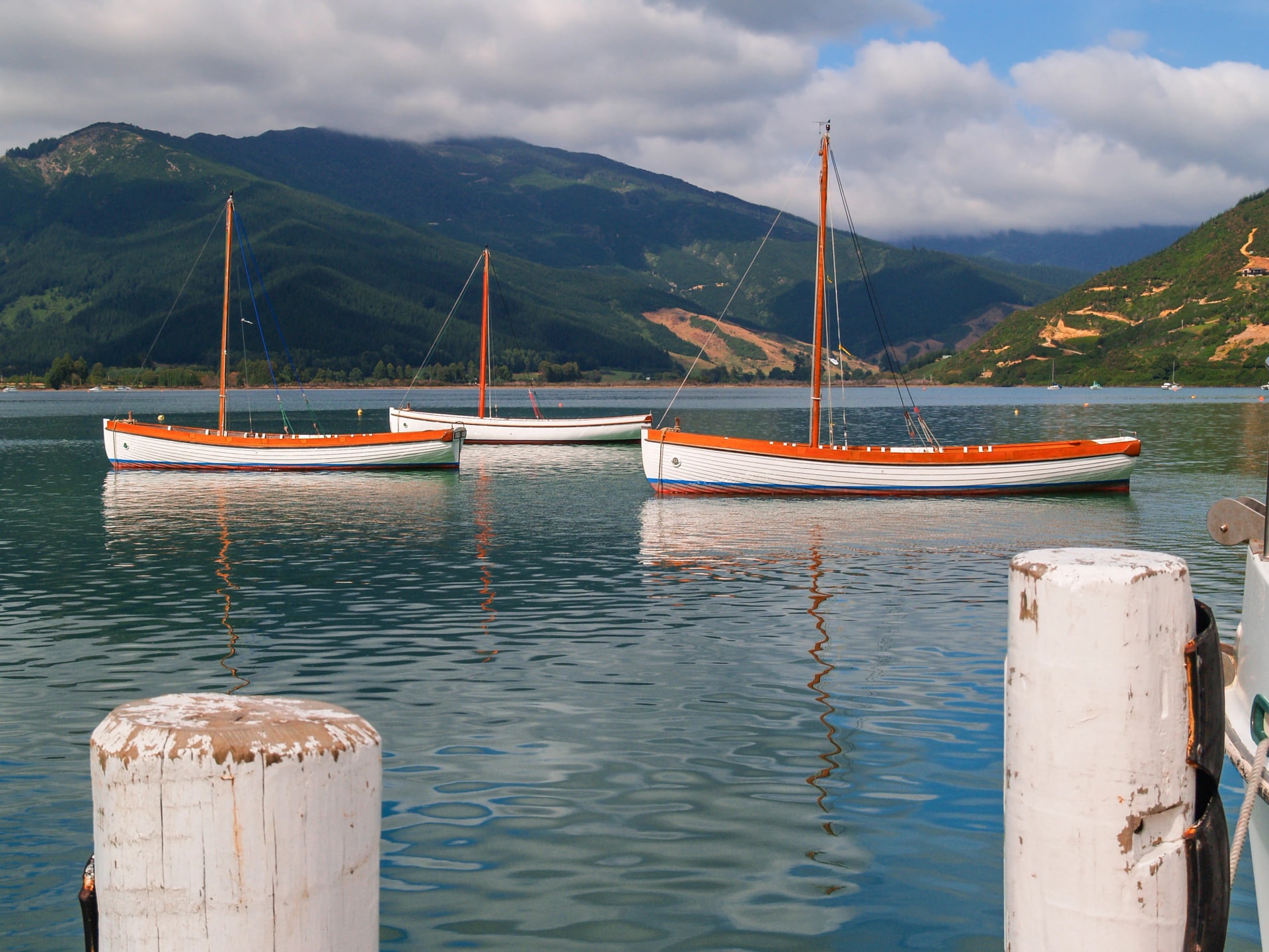 Scenic Kenepuru Sound images clinker sailing boats with masts moored together